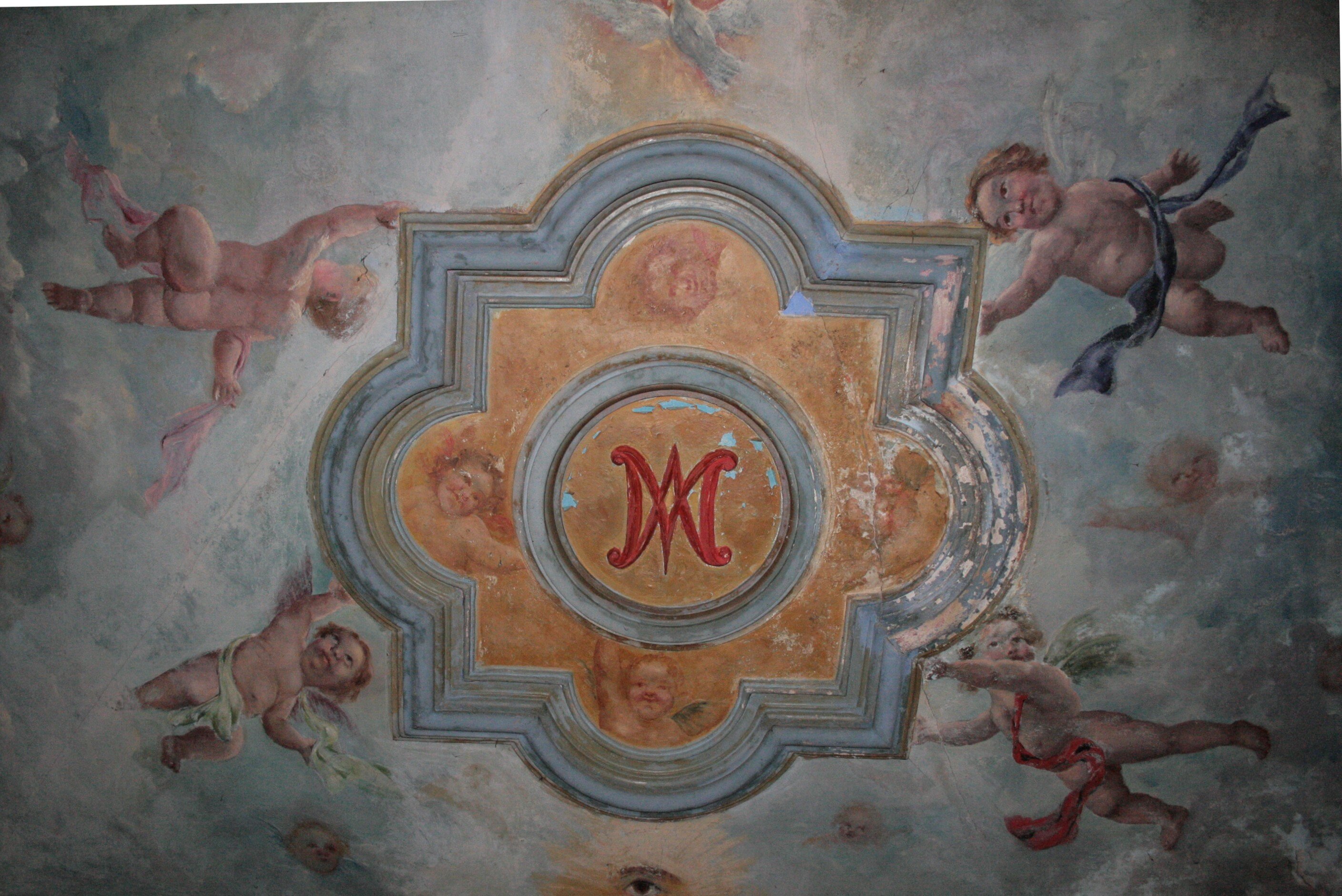 Decoración pictórica con emblema mariano y putti en el oratorio privado